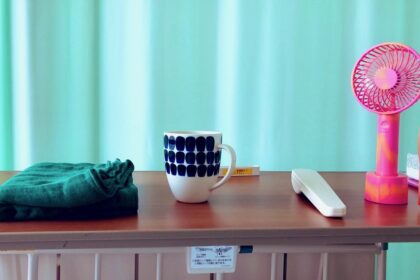 入院先のベッド、テーブルにマグカップや簡易扇風機